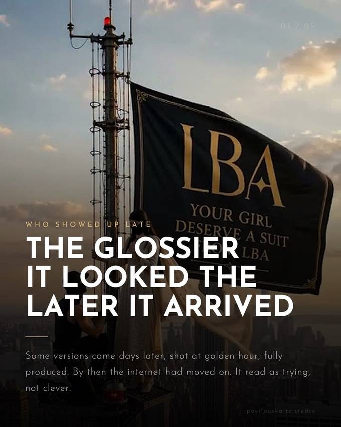A banner reading LBA, Your Girl Deserve A Suit, hung from the Empire State Building antenna at golden hour.