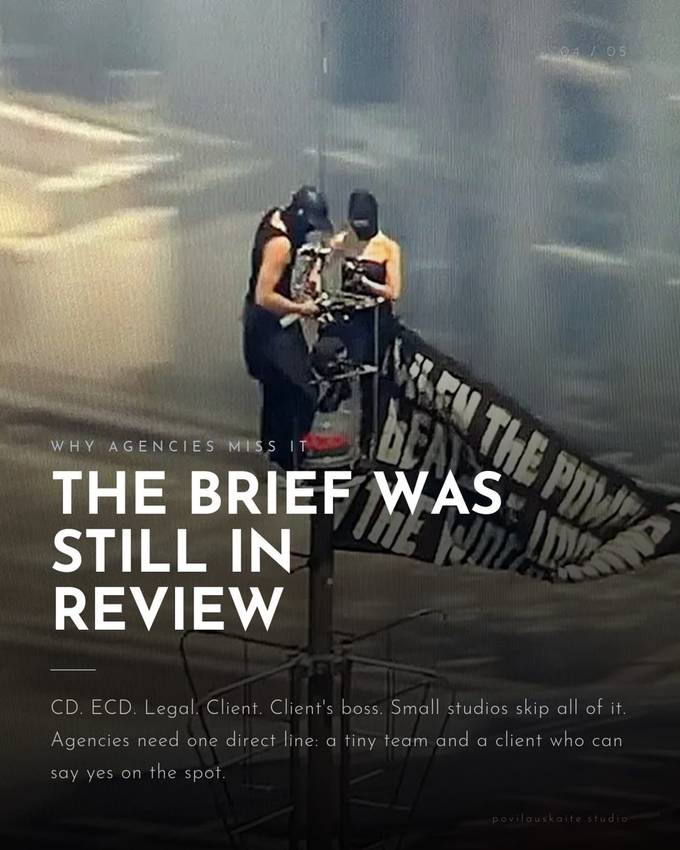 A banner reading The Brief Was Still In Review, hung from the Empire State Building antenna above a foggy city street.