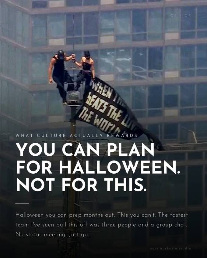A banner reading You Can Plan For Halloween, Not For This, hung from an antenna above a glass office tower.